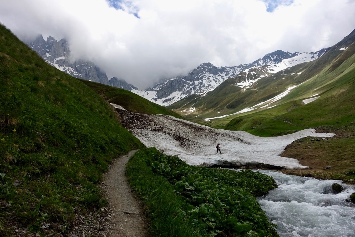 46 hiker traversing an early summer snow bridge juta khevsureti georgia meagan neal transcaucasian trail association